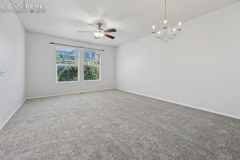 Image 11 of 31: Carpeted empty room with a chandelier and ceiling fan