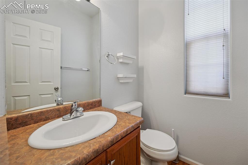 Image 16 of 31: Half bathroom with vanity and a textured wall