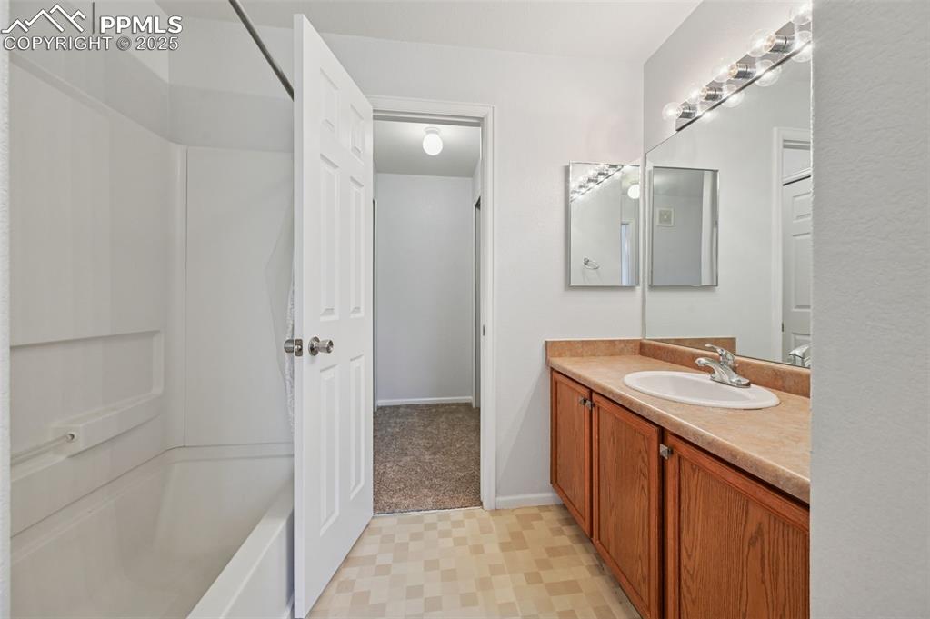 Image 18 of 31: Bathroom with vanity, tub / shower combination, and light floors
