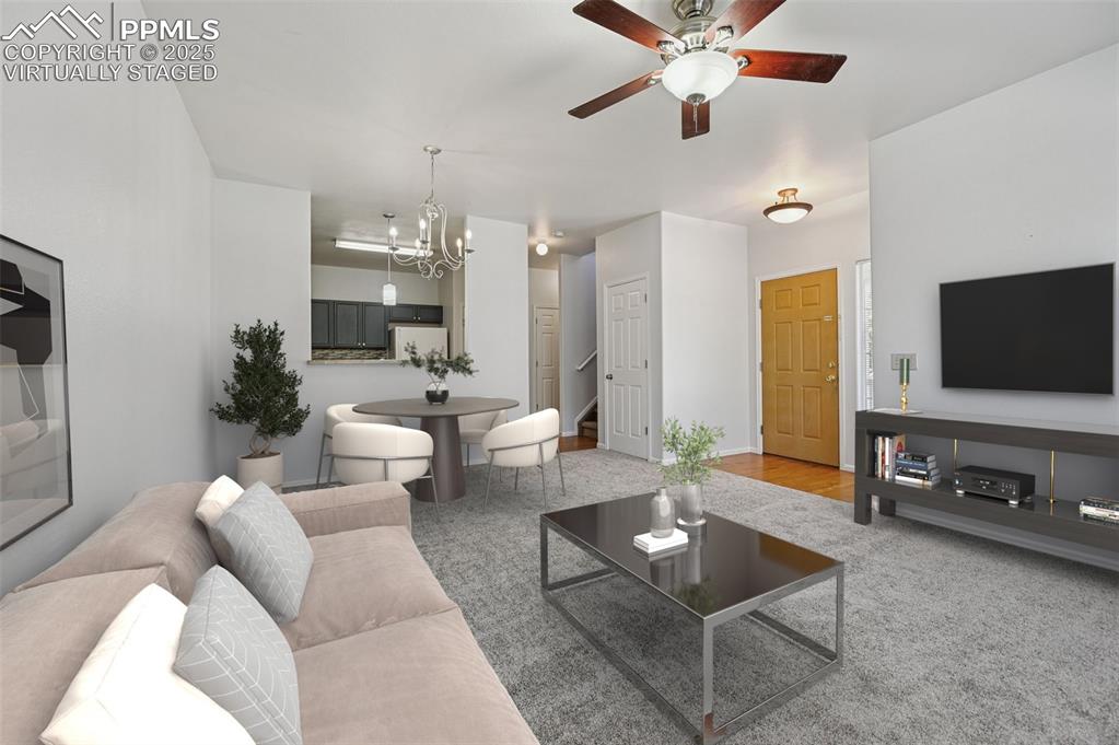 Image 2 of 31: Living room featuring a chandelier, stairway, and ceiling fan. virtually st