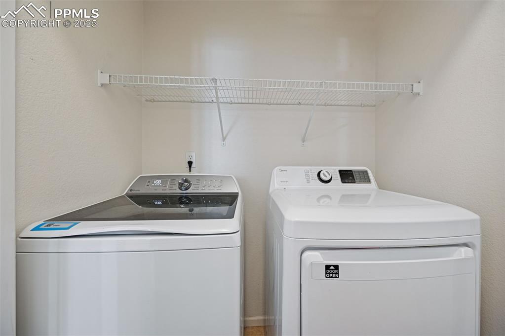 Image 20 of 31: Laundry area with washer and clothes dryer and a textured wall