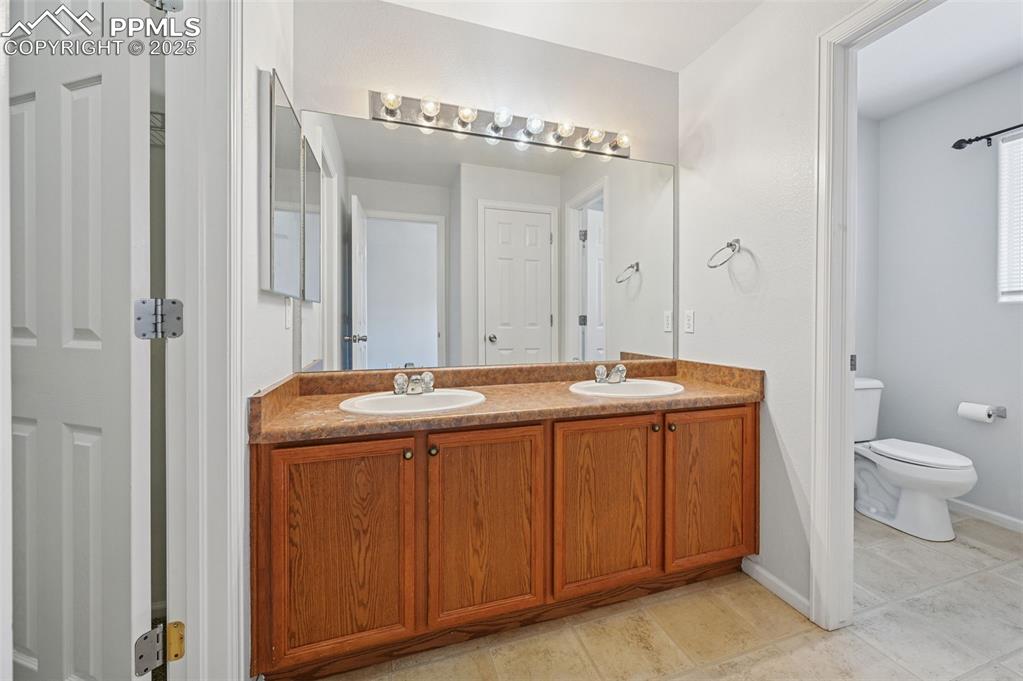 Image 25 of 31: Full bathroom featuring double vanity and light tile patterned floors