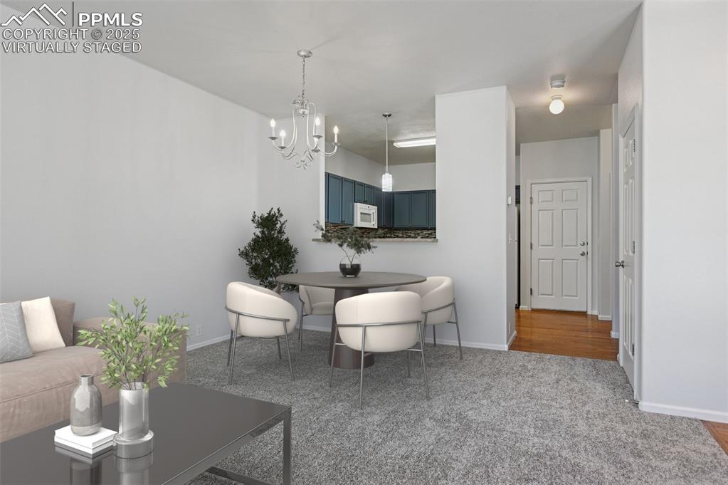 Image 3 of 31: Dining area featuring a chandelier and light colored carpet. virtually stag