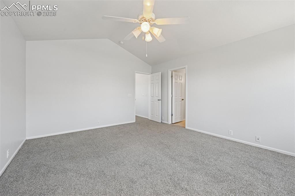 Image 31 of 31: Empty room with lofted ceiling, carpet, and ceiling fan