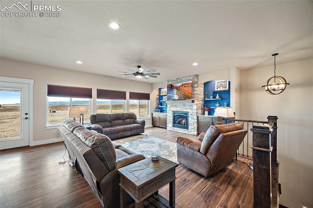 Image 12 of 49: Spacious living room with gas fireplace and mountain views.