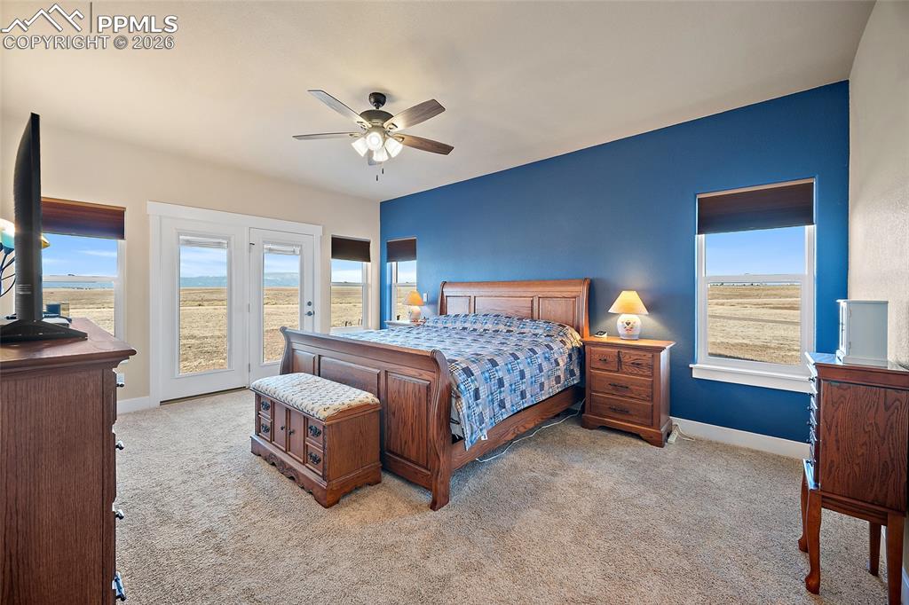 Image 14 of 49: Primary bedroom with walkout to covered patio and mountain views.