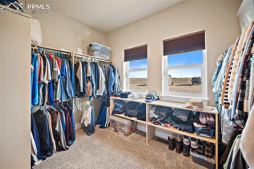 Image 19 of 49: Walk in primary closet.