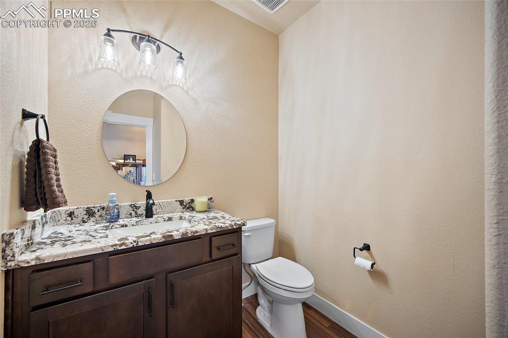 Image 25 of 49: Main level 1/2 bathroom with quartz countertops.
