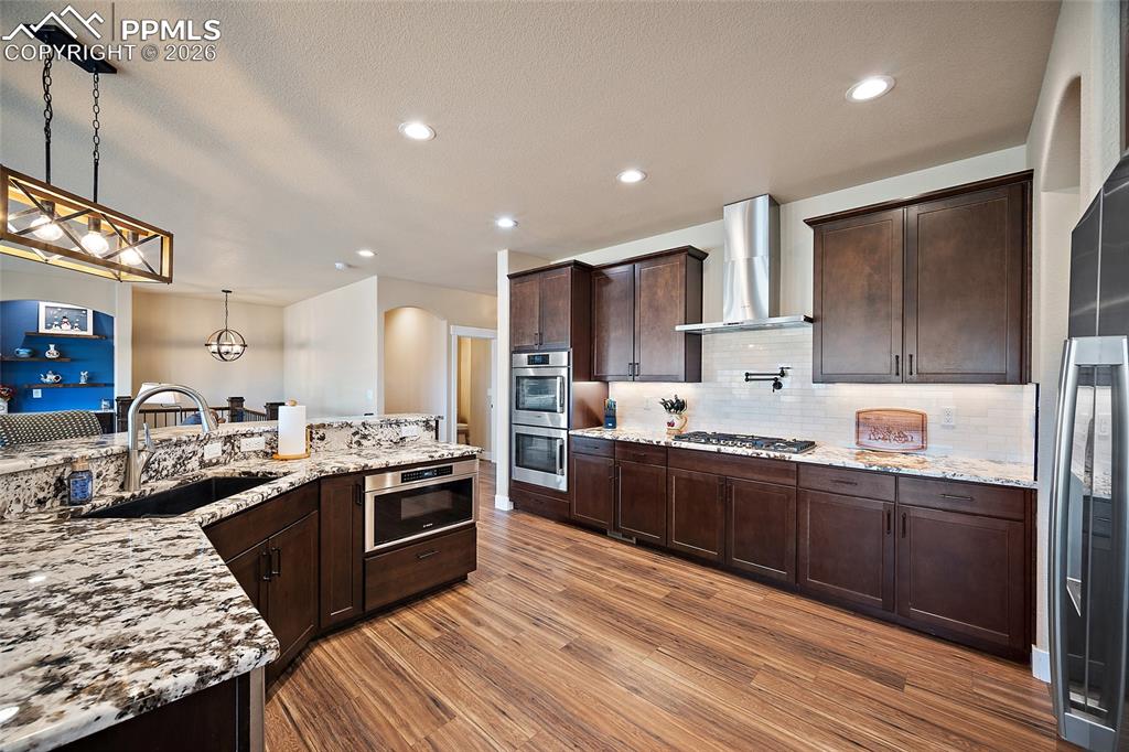 Image 3 of 49: Gourmet kitchen featuring quartz countertops, double ovens, gas cooktop, po