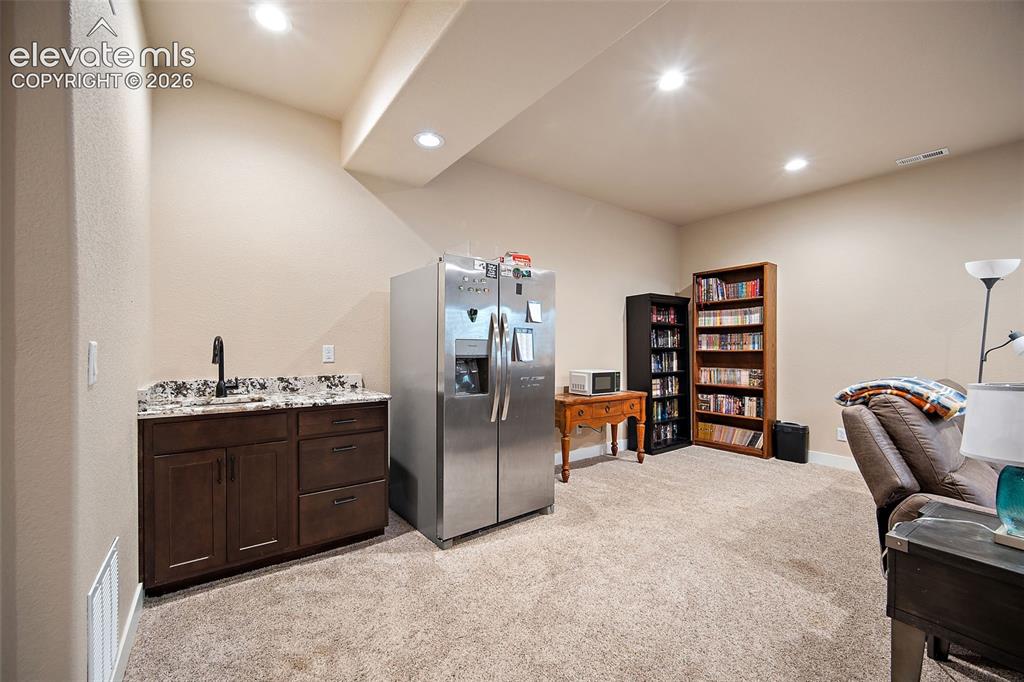Image 30 of 50: Lower level wet bar and refrigerator