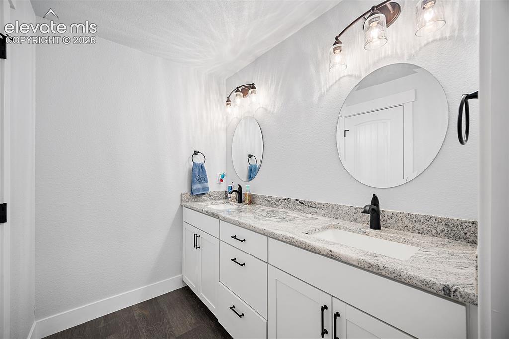 Image 33 of 50: Lower level bathroom with dual vanity