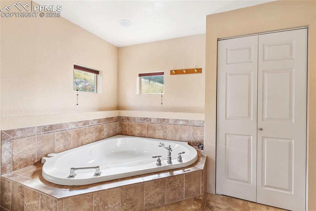 Image 29 of 48: Bathroom featuring a closet and a bath