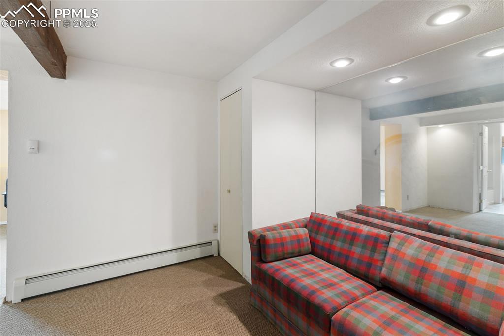 Image 39 of 48: Carpeted living room with a baseboard radiator and recessed lighting