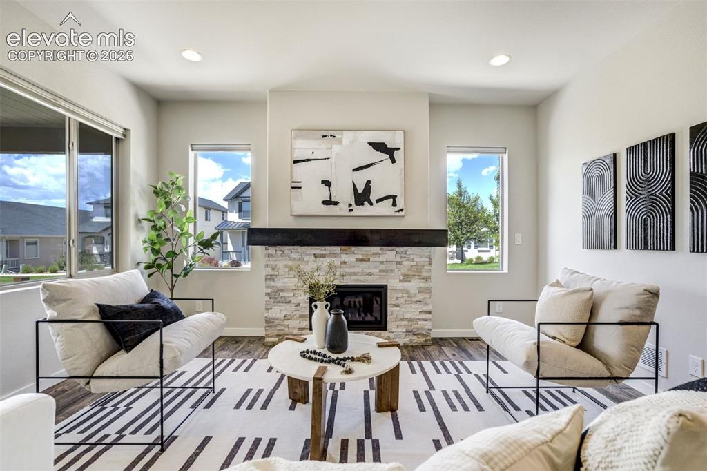 Image 15 of 44: Stone surround fireplace with a mantle in the living room.