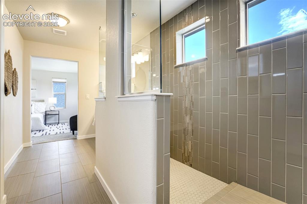 Image 27 of 44: Walk-in shower in the Primary Bathroom. Hallelujah.