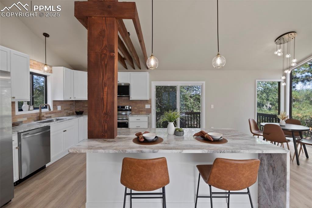 Image 15 of 50: Kitchen featuring decorative light fixtures, tasteful backsplash, lofted ce