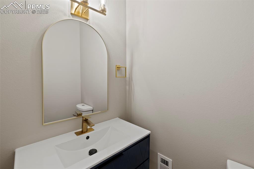 Image 18 of 50: Half bathroom featuring vanity and a textured wall