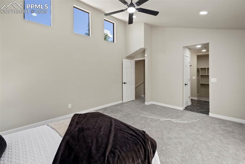 Image 21 of 50: Carpeted bedroom with ceiling fan, recessed lighting, and high vaulted ceil
