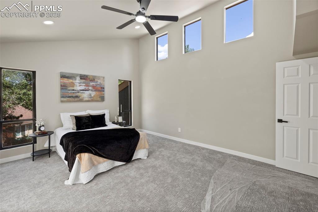 Image 22 of 50: Bedroom featuring carpet floors, a high ceiling, a ceiling fan, and recesse