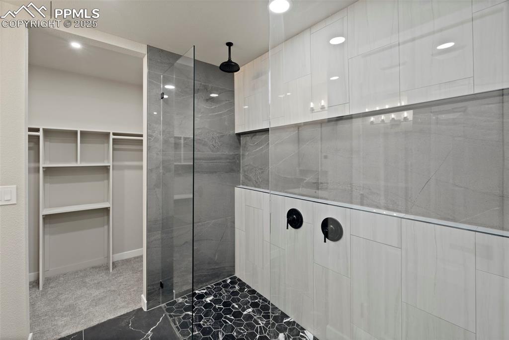 Image 23 of 50: Bathroom with walk in shower, a spacious closet, and recessed lighting