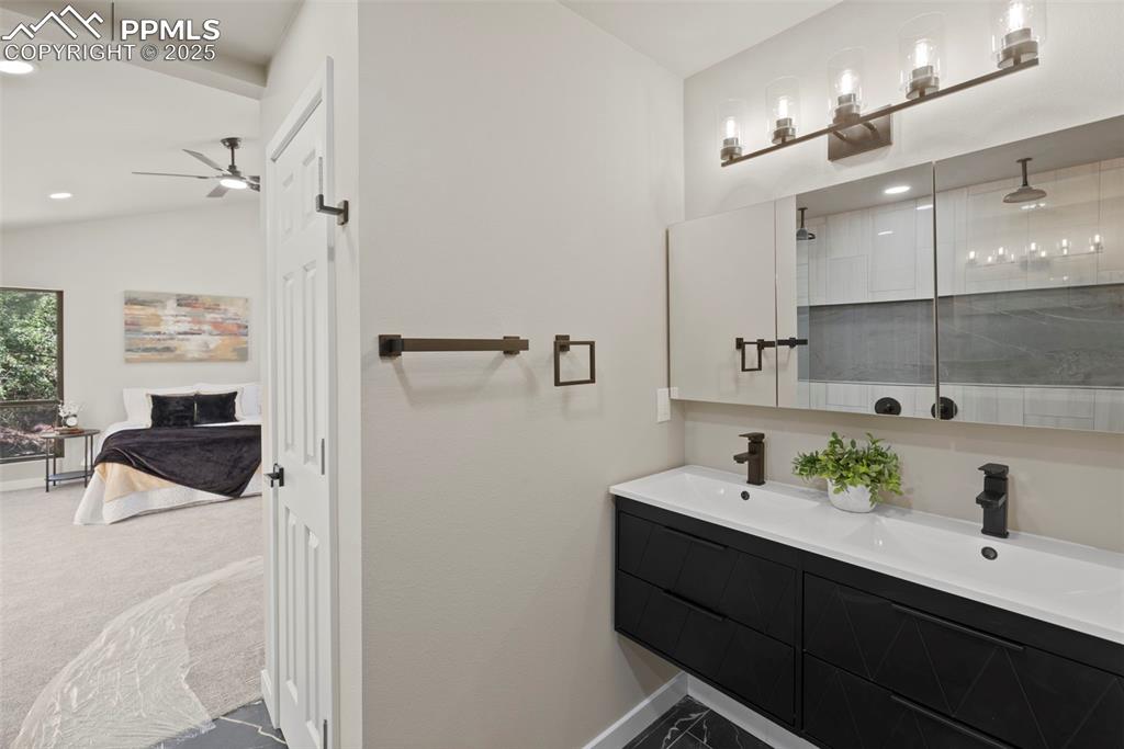Image 25 of 50: Ensuite bathroom with a walk in shower, double vanity, recessed lighting, a