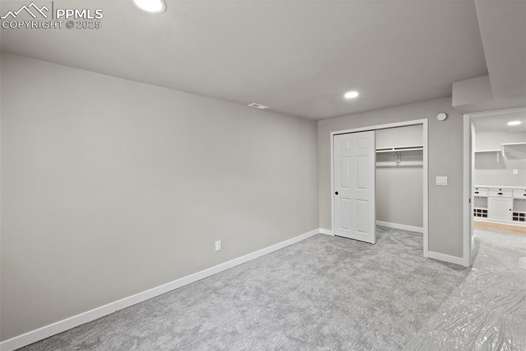 Image 42 of 50: Unfurnished bedroom with recessed lighting, carpet, and a closet
