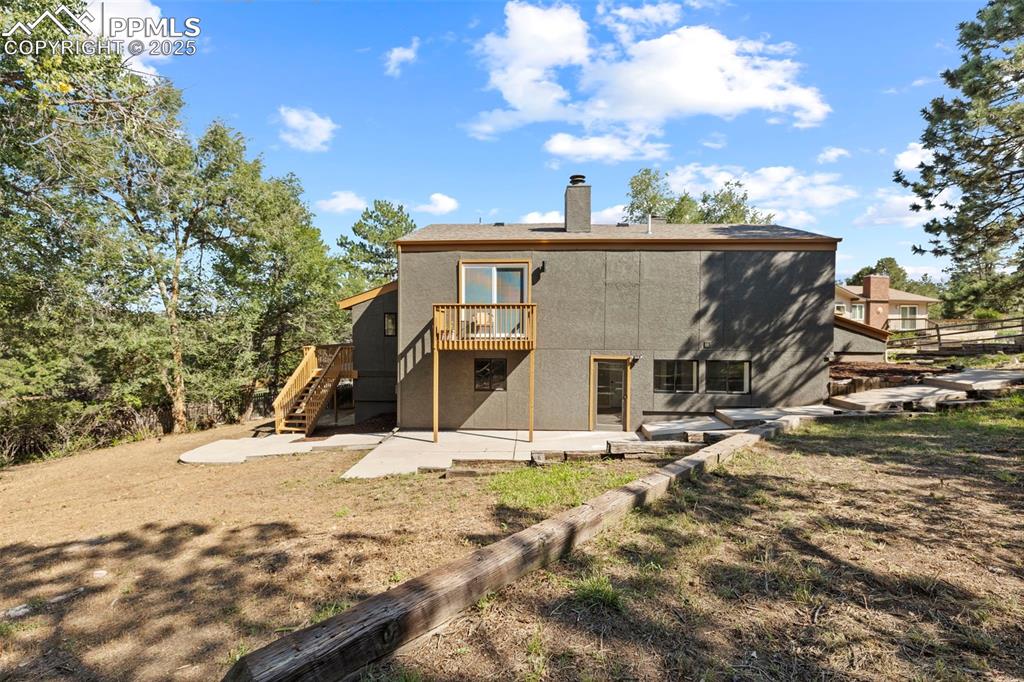 Image 46 of 50: Back of house with a patio, stairway, a chimney, stucco siding, and a deck