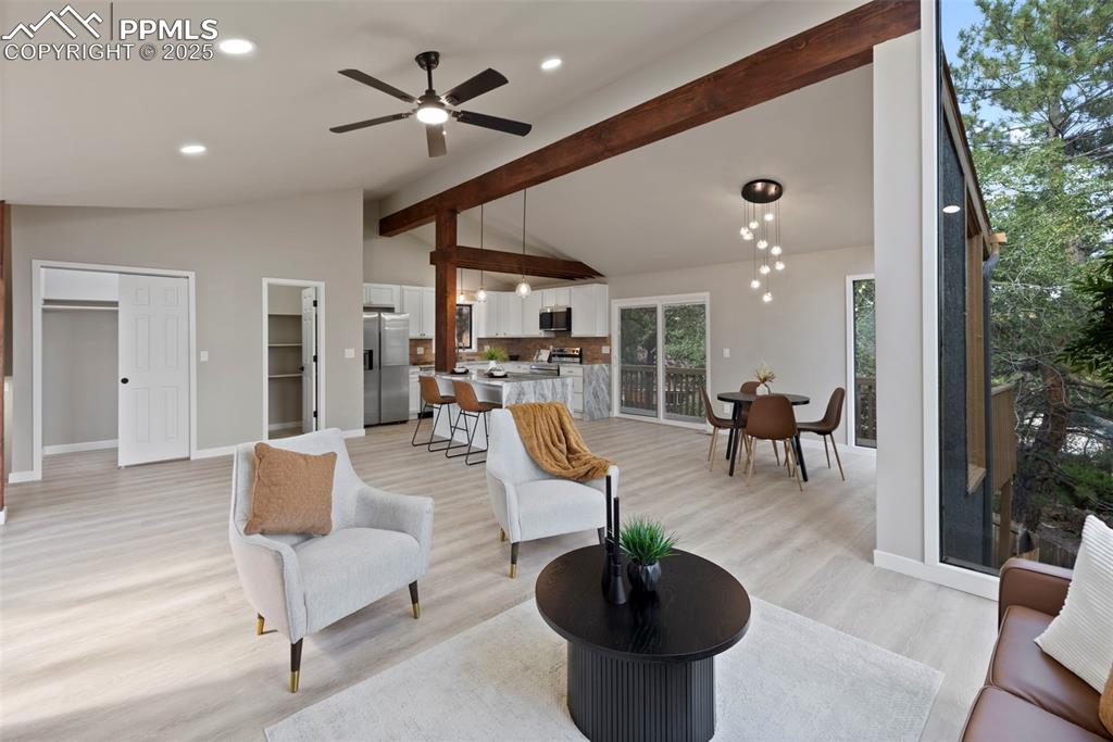 Image 5 of 50: Living room with beam ceiling, light wood finished floors, ceiling fan, rec
