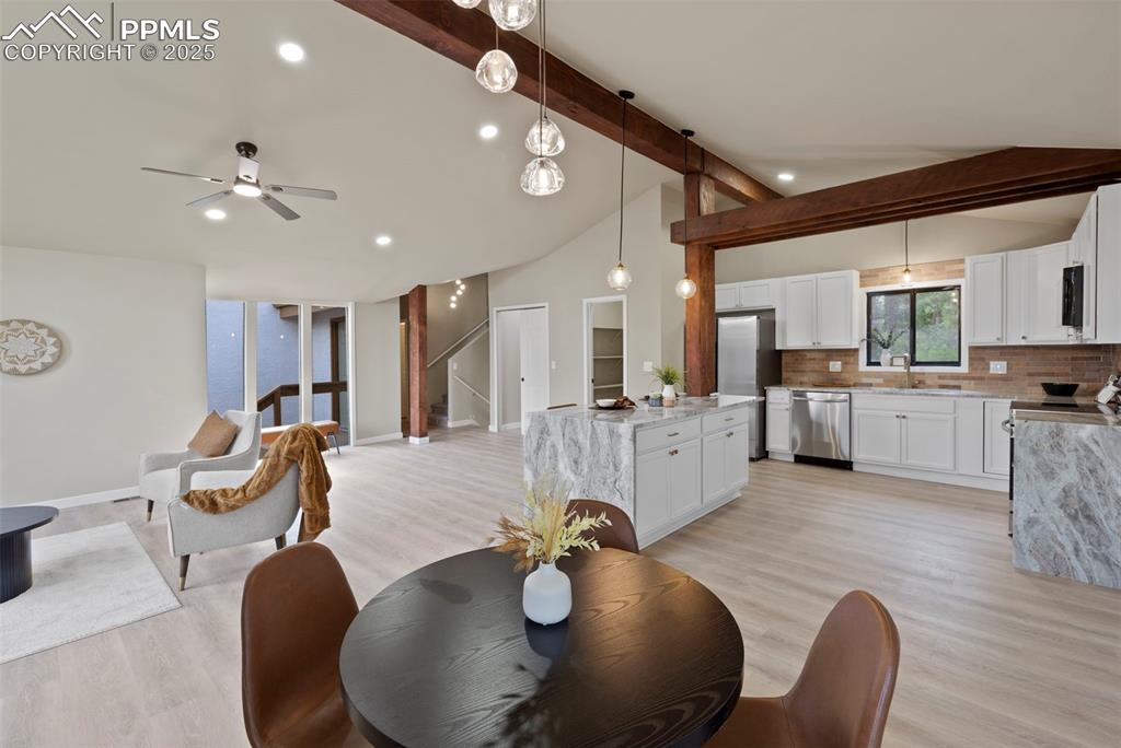 Image 9 of 50: Dining area with light wood-style floors, recessed lighting, ceiling fan, a