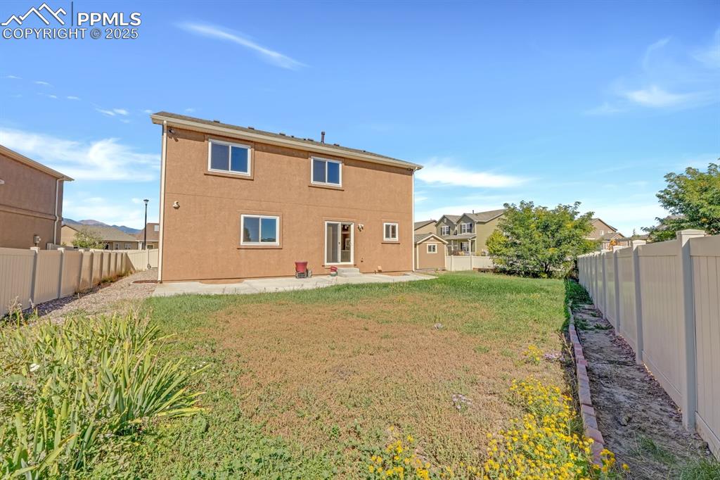Image 30 of 38: Rear view of property featuring a patio, a fenced backyard, and shed 