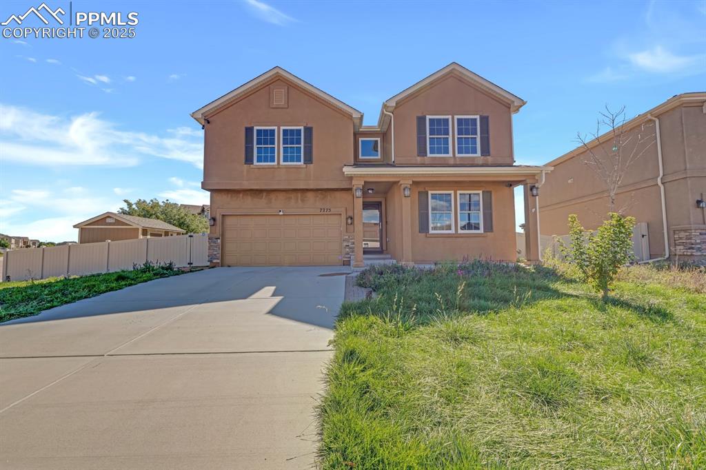 Image 6 of 38: View of front facade with stucco siding, driveway, and an attached garage