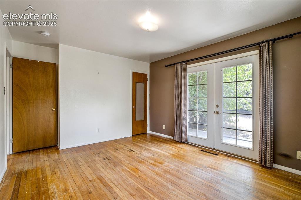 Image 25 of 40: Primary Suite with french doors out to the backyard