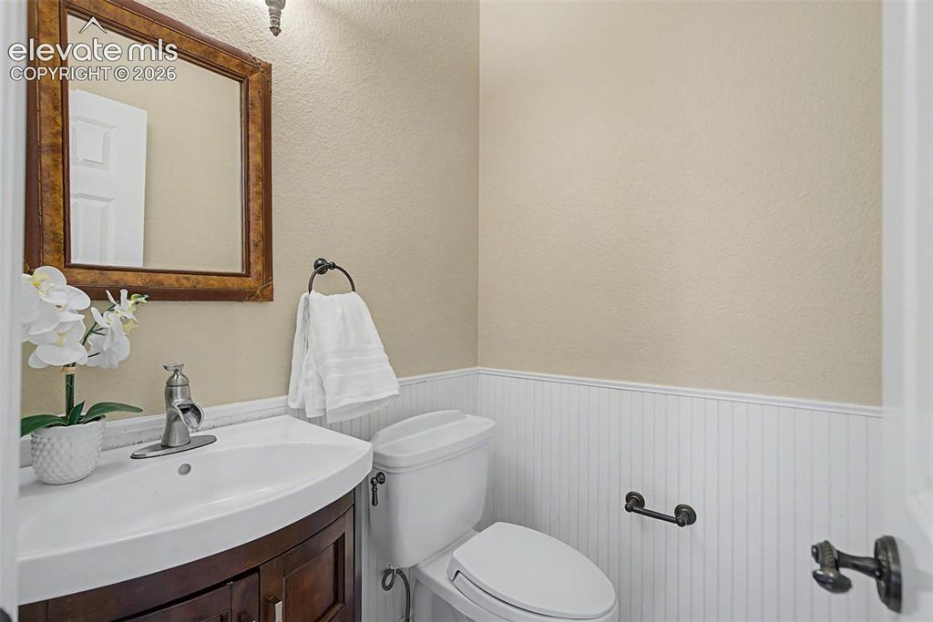 Image 18 of 42: Classic beadboard wainscoting and a rich wood vanity add a touch of timeles