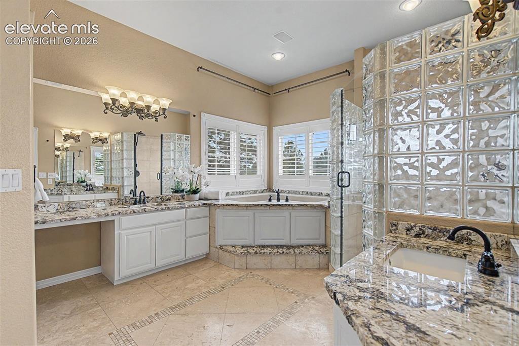 Image 23 of 42: The luxurious five-piece primary bathroom boasts an expansive double vanity