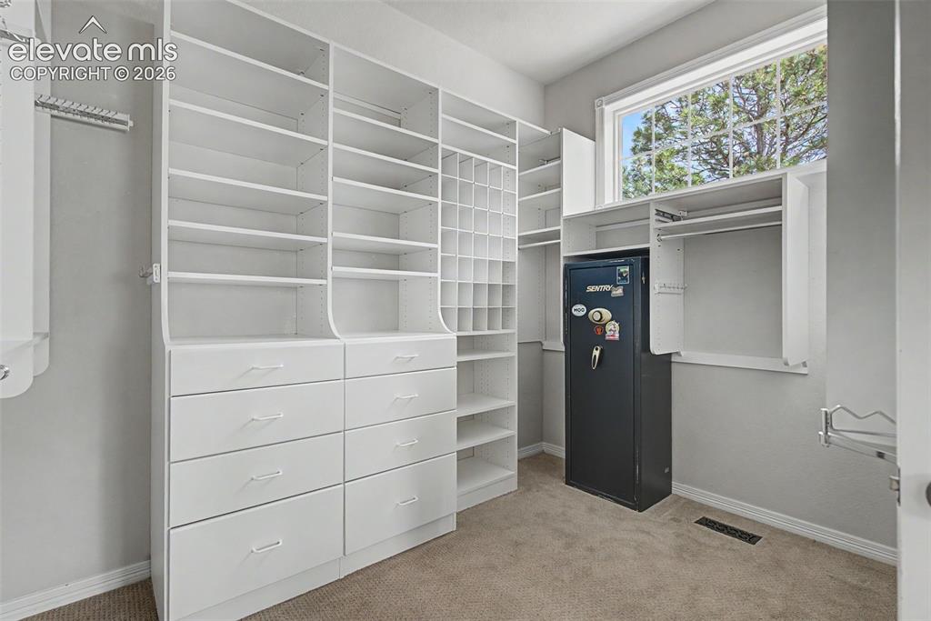 Image 25 of 42: The oversized walk-in closet is fully equipped with built-in organizational