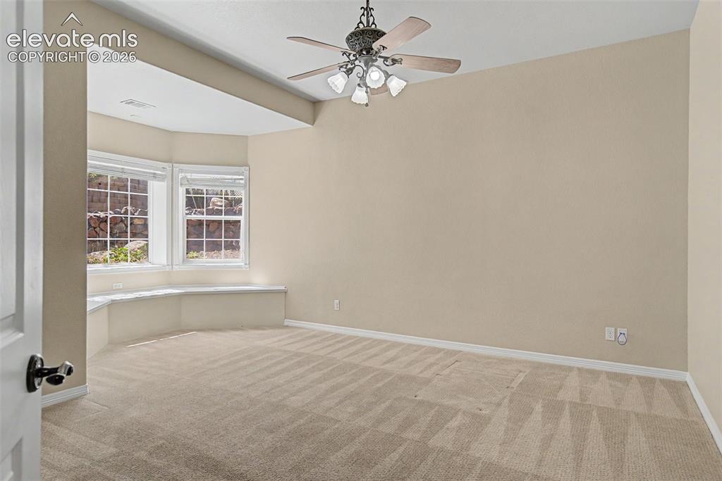 Image 26 of 42: A versatile main level bedroom is highlighted by a deep bay window seat, of