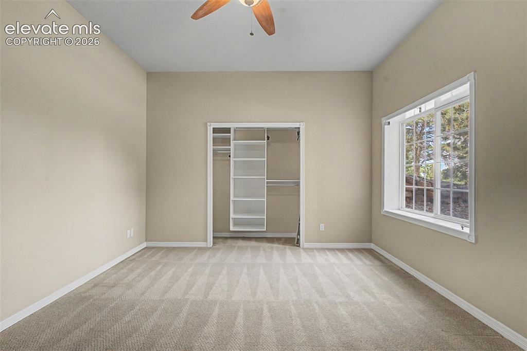 Image 29 of 42: A generously sized lower-level bedroom includes built-in closet organizati