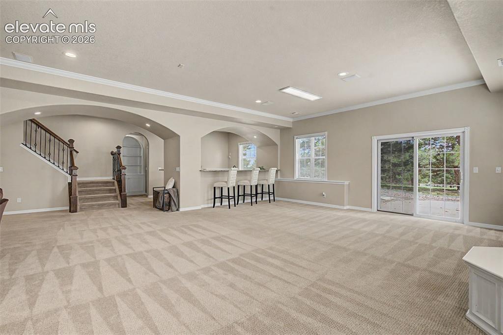 Image 31 of 42: Sliding glass doors in the lower-level recreation space lead directly to th
