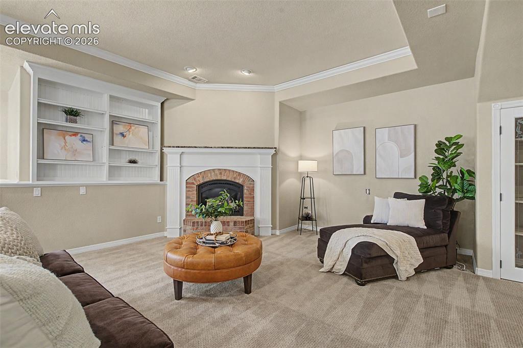 Image 33 of 42: Built-in shelving surrounds the lower-level fireplace, providing an invitin