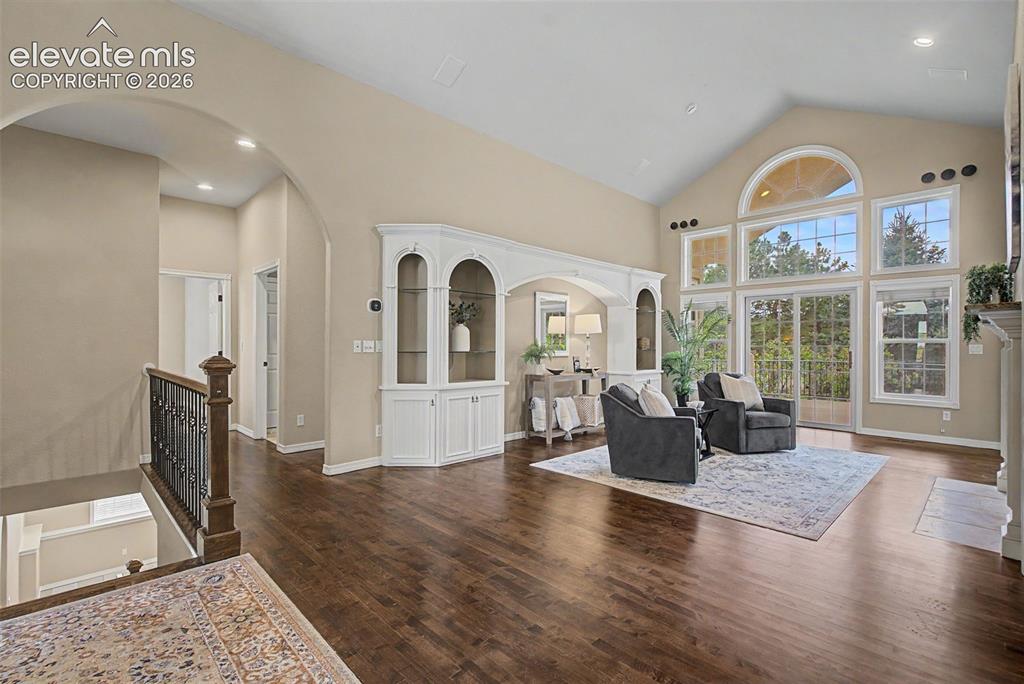 Image 6 of 42: Massive floor-to-ceiling arched windows flood the great room with natural l