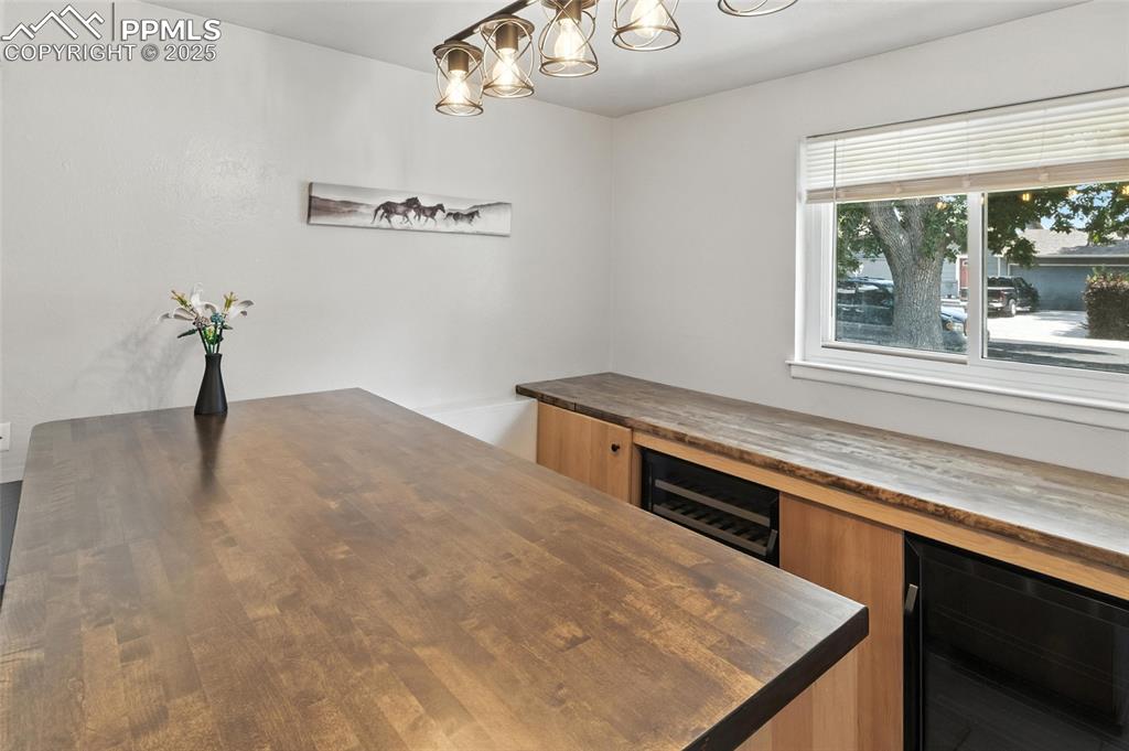 Image 10 of 42: Bar with Wine Cooler and Mini Fridge.