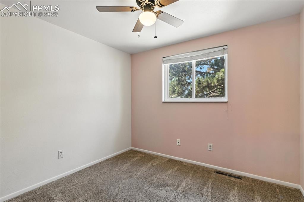 Image 30 of 42: Third Bedroom with Soft Pink Wall.
