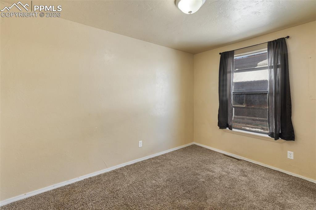 Image 10 of 36: Carpeted empty room with baseboards and a textured ceiling