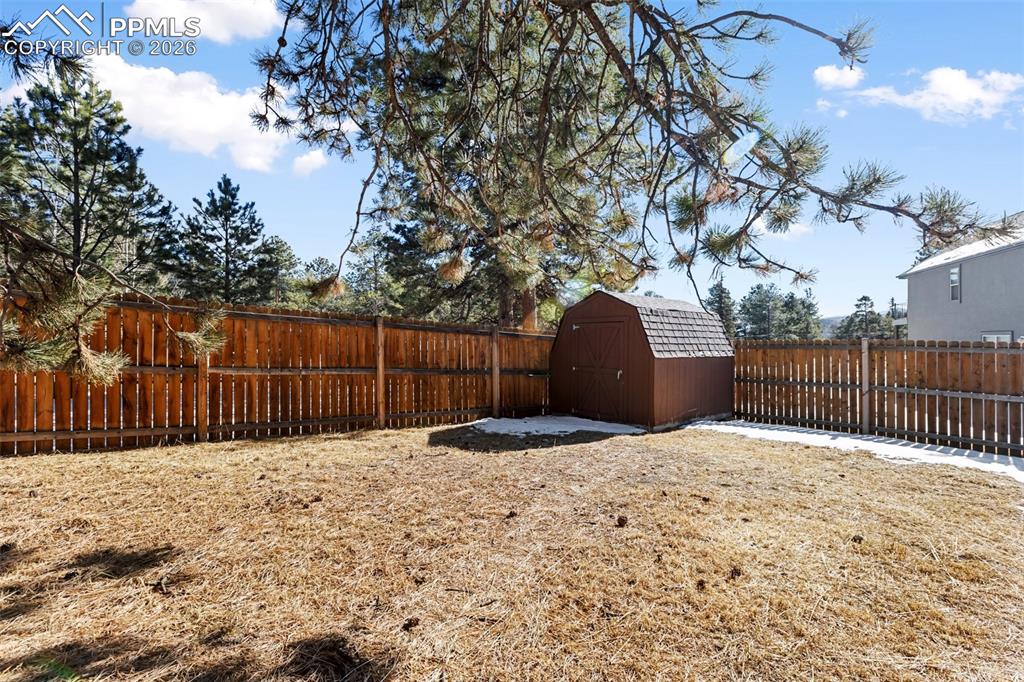 Image 13 of 36: Fenced backyard featuring a storage shed