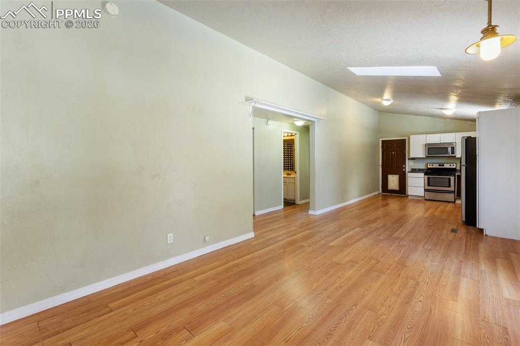 Image 15 of 36: Unfurnished living room featuring lofted ceiling and light wood finished fl