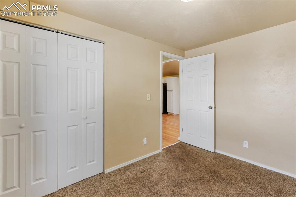 Image 20 of 36: Unfurnished bedroom with a closet and carpet flooring