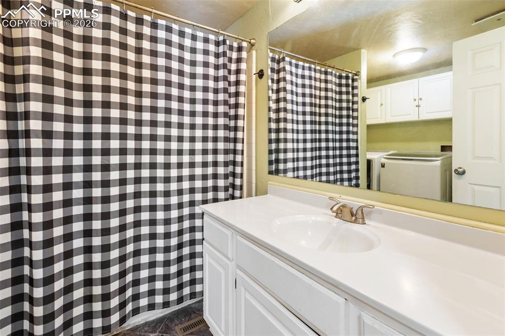 Image 22 of 36: Full bath with a shower with shower curtain and vanity