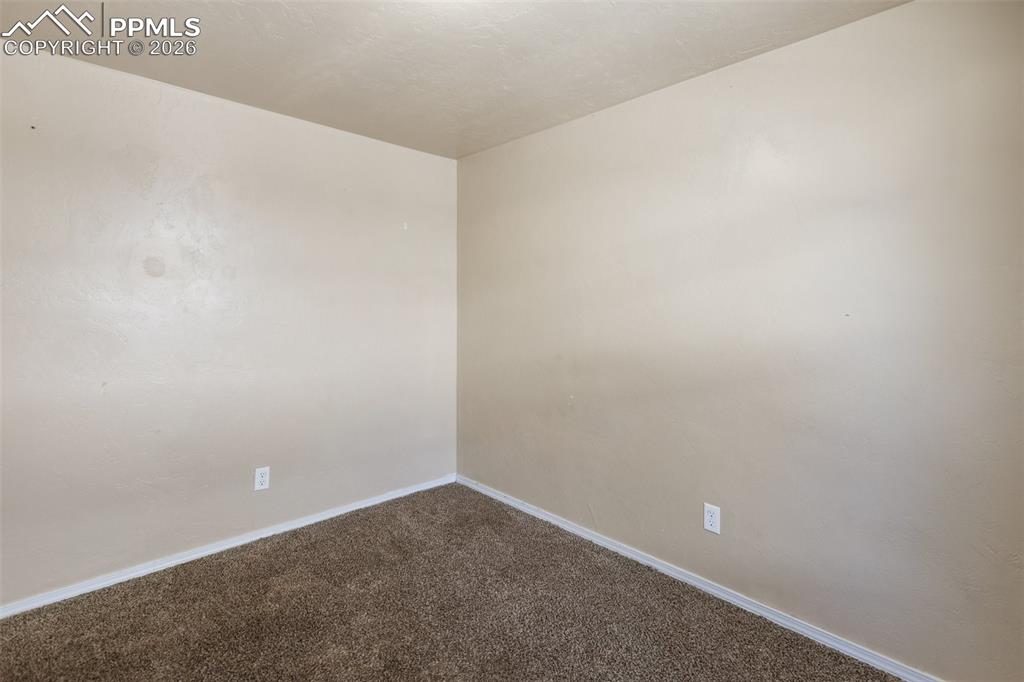 Image 24 of 36: Unfurnished room with carpet and baseboards