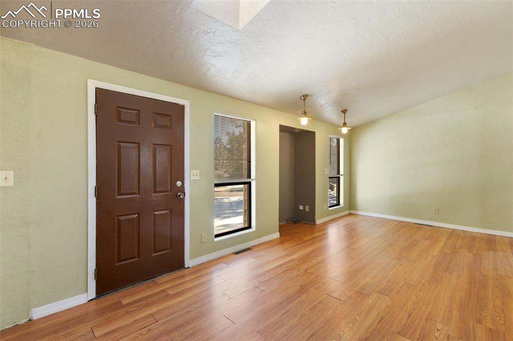 Image 3 of 36: Entrance foyer with light wood-style floors and lofted ceiling