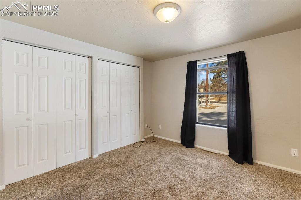 Image 7 of 36: Unfurnished bedroom with two closets and light carpet